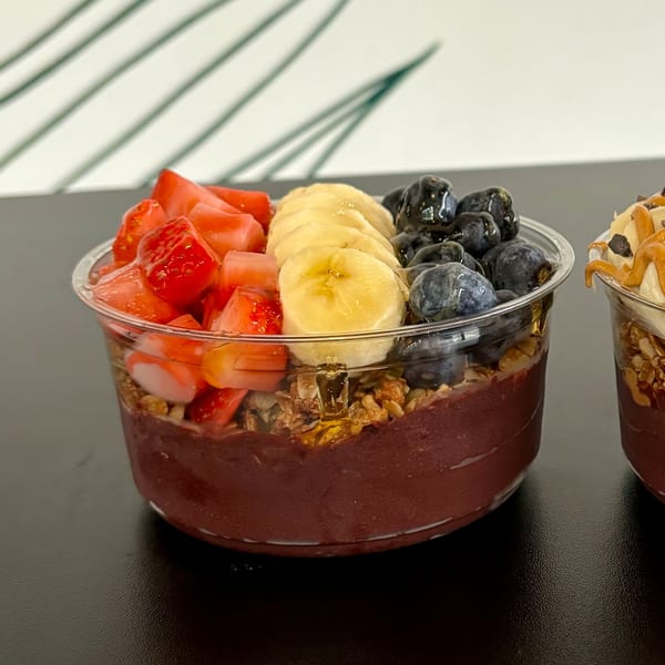A Twenty Two Juice Bar acai bowl with strawberries, bananas, blueberries, and granola.