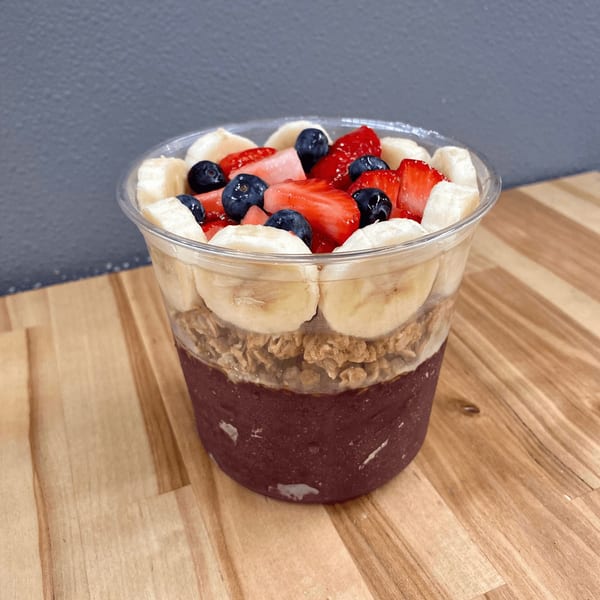 A Twenty Two Juice Bar acai bowl with bananas, granola, strawberries, and blueberries.